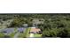 An aerial view of a cozy home with a private pool, surrounded by lush trees in a quiet neighborhood at 22434 Walton Ave, Port Charlotte, FL 33952