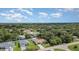 An aerial view of a home in a lush, green neighborhood under a bright blue sky at 22434 Walton Ave, Port Charlotte, FL 33952