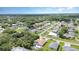An aerial view of a home in a lush, green neighborhood under a bright blue sky at 22434 Walton Ave, Port Charlotte, FL 33952
