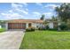 A well-maintained home featuring a spacious garage, stone accents, and a lush green lawn at 22434 Walton Ave, Port Charlotte, FL 33952