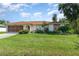 A well-maintained home featuring a spacious garage, stone accents, and a lush green lawn at 22434 Walton Ave, Port Charlotte, FL 33952