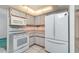 Functional kitchen featuring white appliances, tiled flooring, and ample counter space at 22434 Walton Ave, Port Charlotte, FL 33952