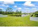 Large grassy backyard with a picturesque pond and white picket fence at 226 Tapa Parish Run, Bradenton, FL 34212