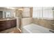 Elegant bathroom featuring a separate tub and shower with beautiful tiling and a granite countertop vanity at 226 Tapa Parish Run, Bradenton, FL 34212