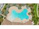 Aerial close-up of a uniquely shaped community pool surrounded by palm trees, lounge chairs, and a tiled roof clubhouse at 226 Tapa Parish Run, Bradenton, FL 34212