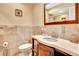Bathroom featuring a vanity with marble countertop and undermount sink, toilet and mirror at 2315 Riverwood Pines Dr, Sarasota, FL 34231