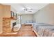 Bedroom with wooden floors, ceiling fan and a fireplace with brick surround and wooden mantel at 2315 Riverwood Pines Dr, Sarasota, FL 34231