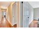 Hallway features wood floors, neutral paint, and access to multiple rooms at 2315 Riverwood Pines Dr, Sarasota, FL 34231