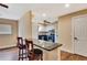 Kitchen bar with seating and a view into a kitchen featuring white cabinets and stainless appliances at 2315 Riverwood Pines Dr, Sarasota, FL 34231