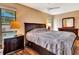 Well-lit main bedroom featuring wooden floors, a large bed, and a dresser with decorative mirror at 2315 Riverwood Pines Dr, Sarasota, FL 34231