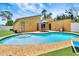 Backyard with a kidney-shaped pool, patio seating, and lush landscaping at 2315 Riverwood Pines Dr, Sarasota, FL 34231