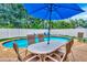 Backyard pool features an outdoor dining area and an umbrella at 2315 Riverwood Pines Dr, Sarasota, FL 34231
