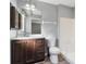 Bathroom featuring a dark wood vanity, a sink, a white countertop, a large mirror, and vinyl floors at 2405 Mistleto Ln, North Port, FL 34286