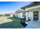Inviting front entrance with a well-kept lawn, complemented by neat landscaping and a covered porch at 2405 Mistleto Ln, North Port, FL 34286