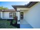 Inviting front porch with decorative columns, lush landscaping, and a stylish front door at 2405 Mistleto Ln, North Port, FL 34286