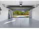 A clean and spacious garage featuring an epoxy floor, modern lighting, and a view to the outdoors at 2405 Mistleto Ln, North Port, FL 34286