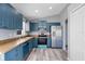 Bright kitchen with stylish blue cabinets, stainless steel appliances, and wood-look flooring at 2405 Mistleto Ln, North Port, FL 34286