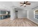 Spacious living room with wood-look floors transitioning to the kitchen with blue cabinets at 2405 Mistleto Ln, North Port, FL 34286