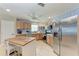 Bright eat-in kitchen features stainless steel appliances, wood cabinetry, an island, and patterned wall decor at 2406 15Th W St, Palmetto, FL 34221
