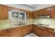 A compact vintage kitchen with stainless steel sink and wooden cabinets at 2850 Bon Air Ave, Sarasota, FL 34234