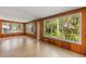 Bright living room featuring wood paneled walls, tile floor, and large windows with backyard views at 2850 Bon Air Ave, Sarasota, FL 34234