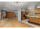 Open-concept living room featuring a fireplace, wood floors, and vintage kitchen with breakfast bar at 2850 Bon Air Ave, Sarasota, FL 34234