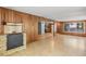 Open living room with wood paneling, fireplace, and access to the vintage kitchen at 2850 Bon Air Ave, Sarasota, FL 34234