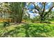 Large backyard with mature trees and a wood fence at 3217 Oak Grove Dr, Sarasota, FL 34243