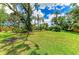 Spacious backyard with lush landscaping, mature trees and palms, creating a serene outdoor oasis at 3217 Oak Grove Dr, Sarasota, FL 34243