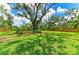 Large backyard with mature trees and a wood fence at 3217 Oak Grove Dr, Sarasota, FL 34243