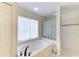 Bathroom featuring a soaking tub with a tile surround, glass block window and a glass enclosed shower at 3217 Oak Grove Dr, Sarasota, FL 34243