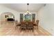 Dining room with terracotta tile flooring, dark wood table, six chairs, and decorative wall hangings at 3217 Oak Grove Dr, Sarasota, FL 34243