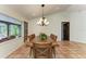 Dining room with terracotta tile flooring, dark wood table, six chairs, and view of the lanai at 3217 Oak Grove Dr, Sarasota, FL 34243