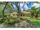 A charming home with a garage and well-manicured lawn and lush tropical garden at 3217 Oak Grove Dr, Sarasota, FL 34243