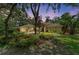 Charming home with a well-manicured lawn and lush tropical garden under a pink sky at 3217 Oak Grove Dr, Sarasota, FL 34243