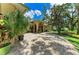 Beautiful home exterior with brick paved driveway, plants and trees against a blue sky at 3217 Oak Grove Dr, Sarasota, FL 34243