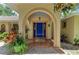 A charming front porch features an arched entryway and a vibrant blue door at 3217 Oak Grove Dr, Sarasota, FL 34243