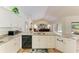 Updated kitchen featuring granite countertops, white cabinetry, and stainless steel dishwasher at 3217 Oak Grove Dr, Sarasota, FL 34243