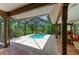 Enclosed lanai with tile flooring, wood columns, and a view of the pool at 3217 Oak Grove Dr, Sarasota, FL 34243
