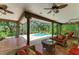 Lanai featuring a covered patio with brick flooring, ceiling fans, and outdoor seating area overlooking pool at 3217 Oak Grove Dr, Sarasota, FL 34243