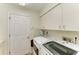 The laundry room includes full size washer and dryer and overhead storage at 3217 Oak Grove Dr, Sarasota, FL 34243