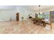 Open-concept living and dining area with large tile floors, a white couch and a wooden table at 3217 Oak Grove Dr, Sarasota, FL 34243