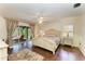 Bright main bedroom with hardwood floors, ceiling fan, slider to backyard pool, and ensuite bath at 3217 Oak Grove Dr, Sarasota, FL 34243