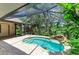 Screened pool with a rock waterfall feature and serene backyard landscaping at 3217 Oak Grove Dr, Sarasota, FL 34243