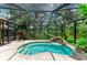 Screened pool with a rock waterfall feature and serene backyard landscaping at 3217 Oak Grove Dr, Sarasota, FL 34243