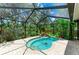 Screened pool with a rock waterfall feature and tropical backyard landscaping at 3217 Oak Grove Dr, Sarasota, FL 34243