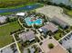 An aerial view shows a resort-style pool area with lush landscaping, amenities, and buildings in this community at 3355 Hilltop Cir, Bradenton, FL 34211