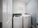 A compact laundry room with white washer and dryer and a small window above at 3355 Hilltop Cir, Bradenton, FL 34211