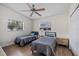This bedroom features two twin beds, ceiling fan, and plenty of natural light at 3641 Stokes Dr, Sarasota, FL 34232