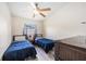 Bright bedroom with ceiling fan, window, and two beds with blue comforters at 3641 Stokes Dr, Sarasota, FL 34232